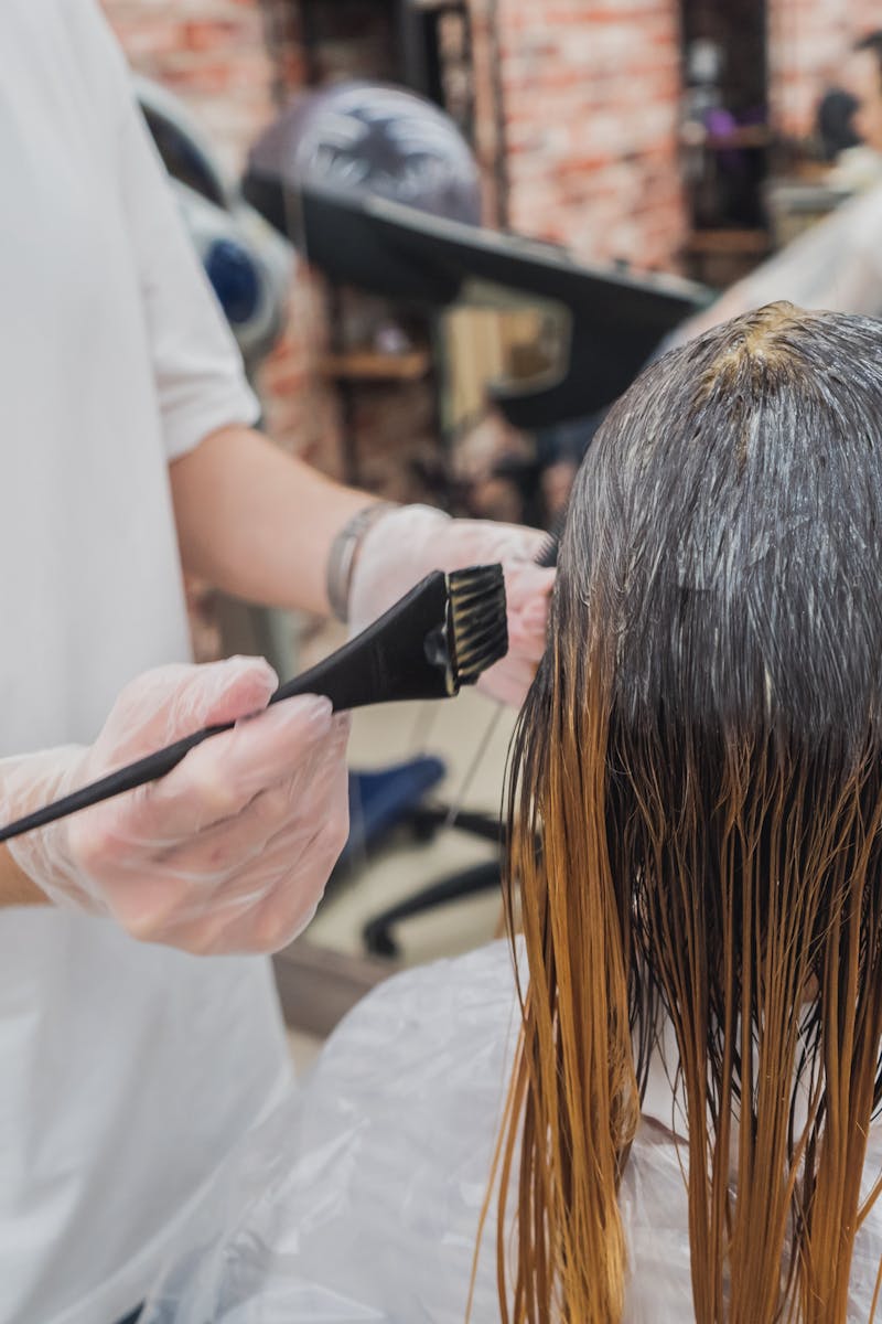Home Hair coloring process in a salon, showcasing stylist applying color to client